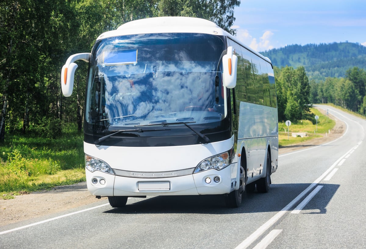 A Dreamline coach travelling a scenic Kenyan country road